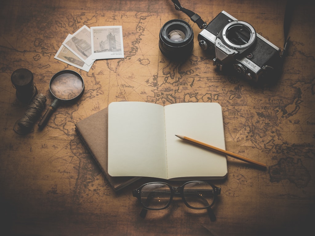Kenya travel itinerary planning with map, notebook and safari lodge photos